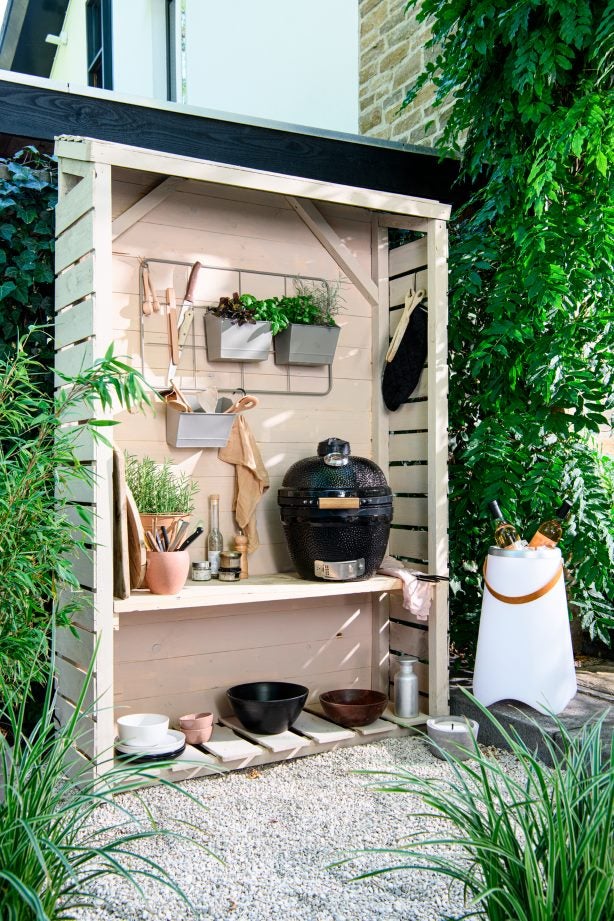Buitenkeuken met een barbecue in een houtopslag